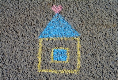 Photo of House with heart drawn by blue and yellow chalk on asphalt, top view