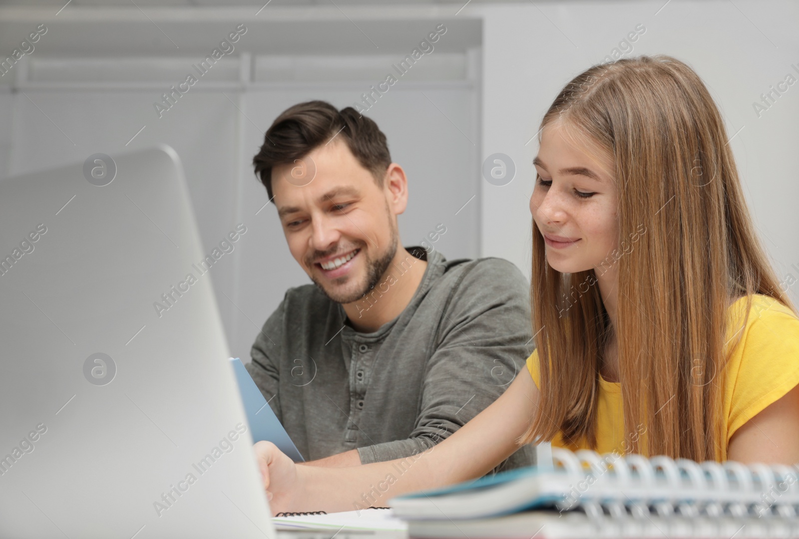 Photo of Father helping his teenager daughter with homework indoors