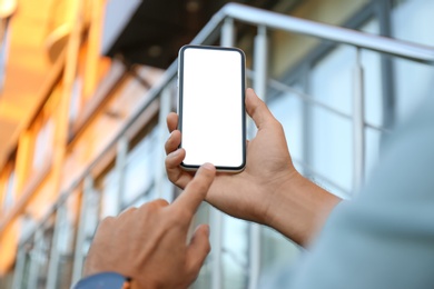 Man using modern mobile phone outdoors, closeup