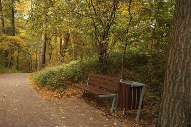 Photo of Many beautiful trees, bench and pathway in autumn park