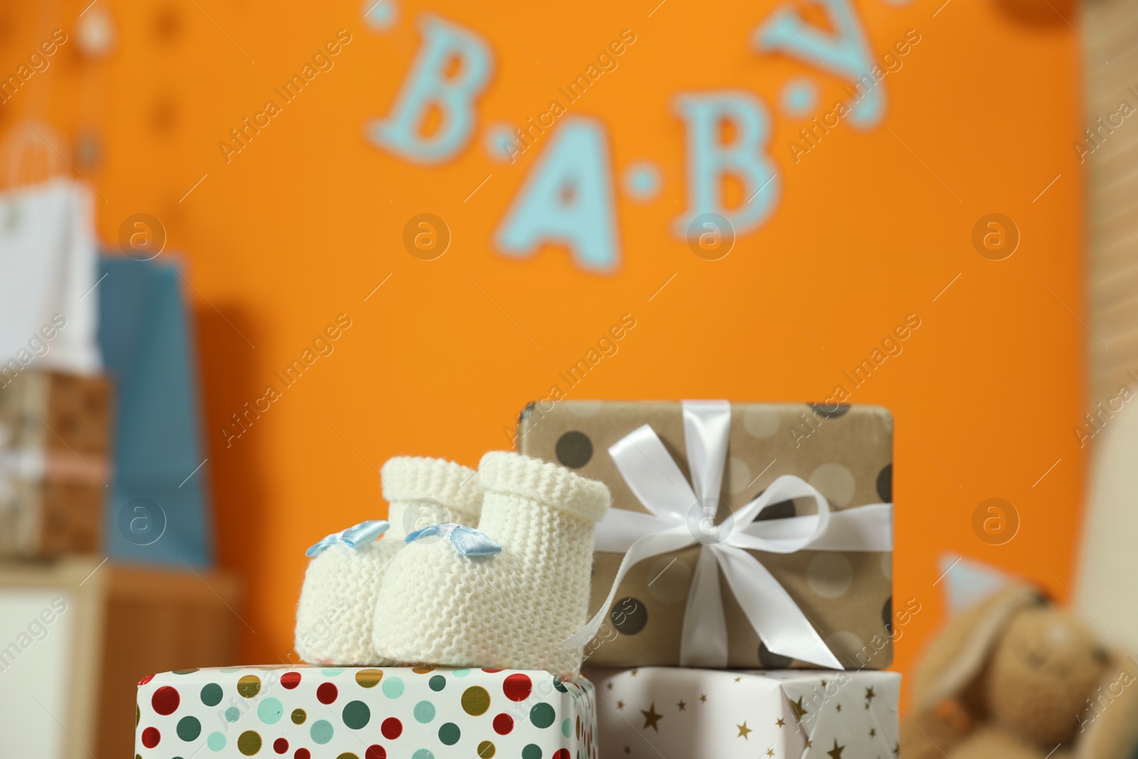 Photo of Baby shower party. Festive decor, gift boxes and booties in stylish room, space for text