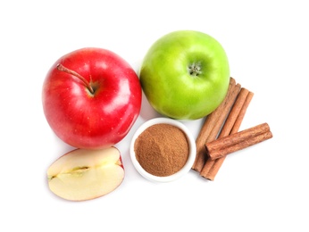 Fresh apples with cinnamon sticks and powder on white background