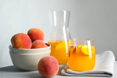 Photo of Tasty peach cocktail on table. Refreshing drink