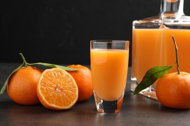 Photo of Delicious tangerine liqueur and fresh fruits on grey table