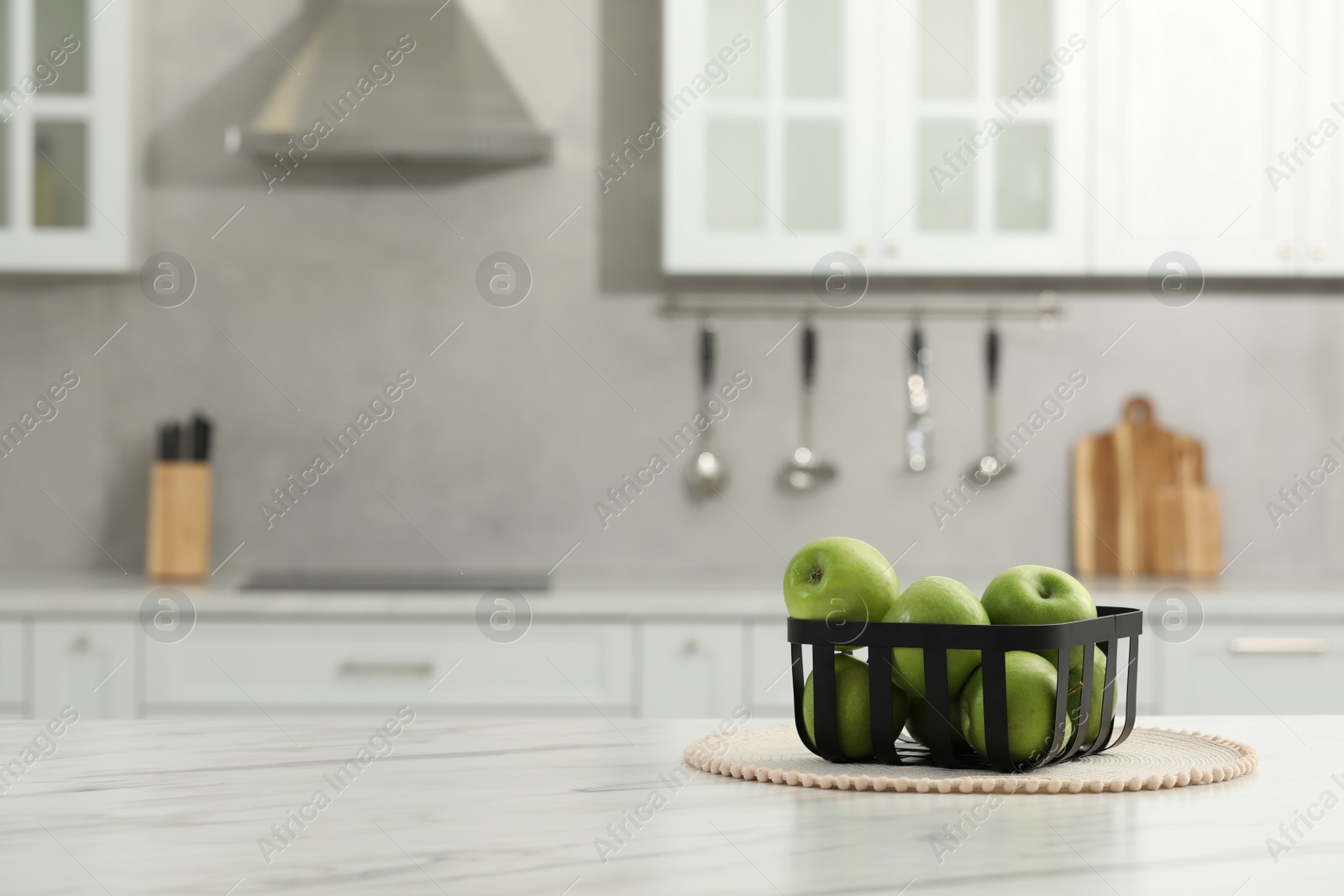 Photo of Fresh green apples on white table in kitchen, space for text