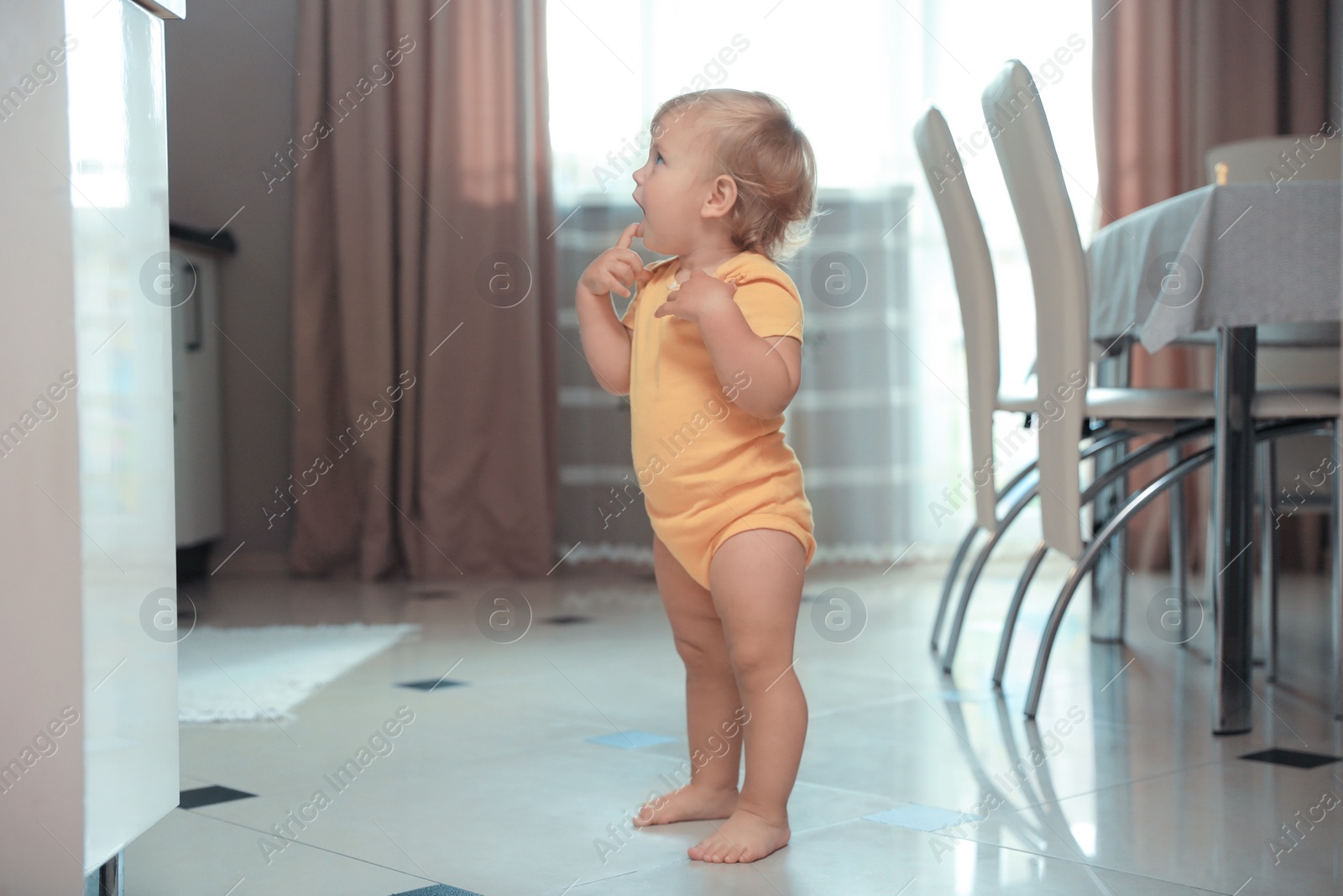 Photo of Cute baby learning to walk in room