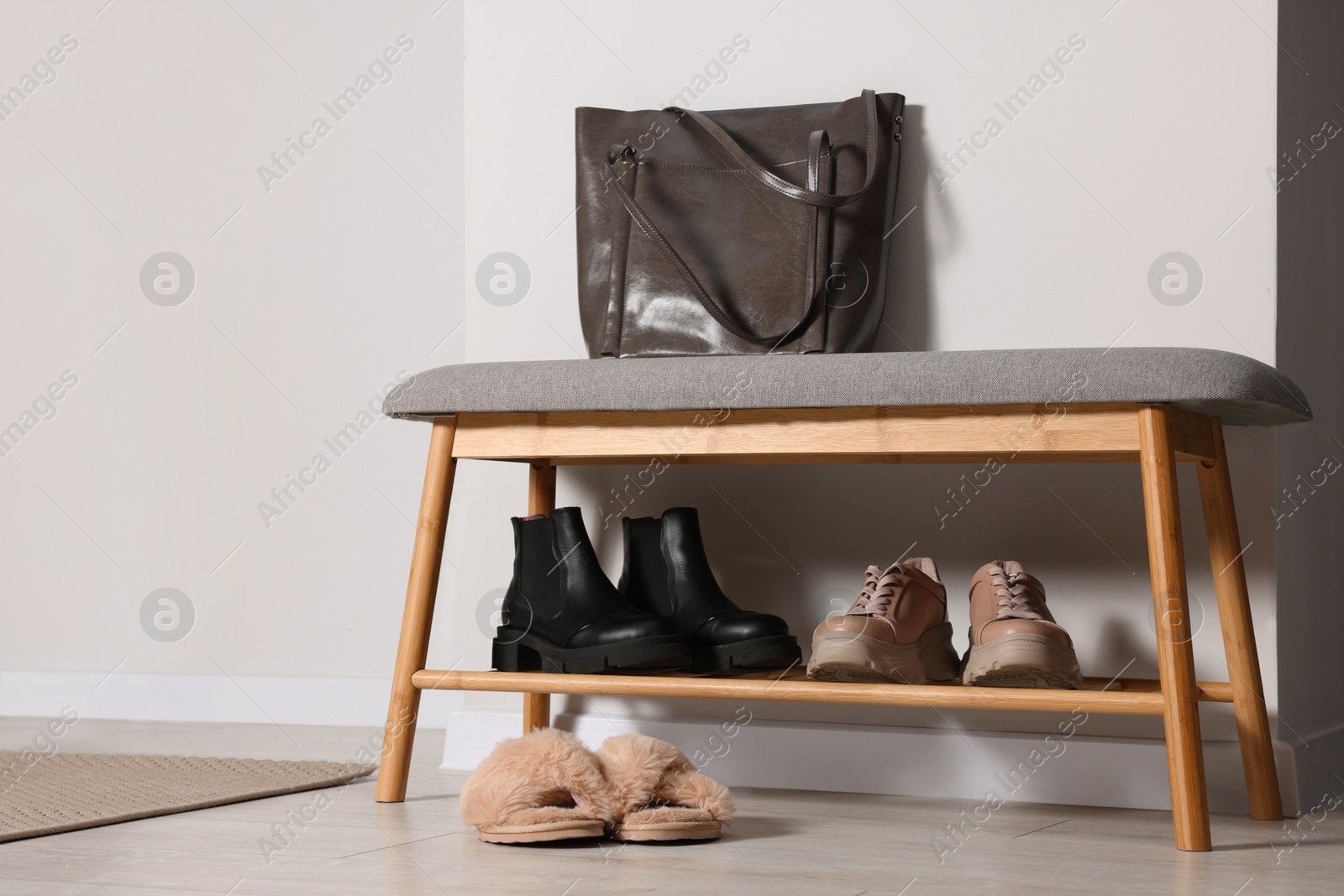 Photo of Shoe storage bench near white wall in hallway. Interior design