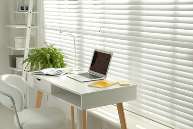 Photo of Modern laptop with calendar app at table in office