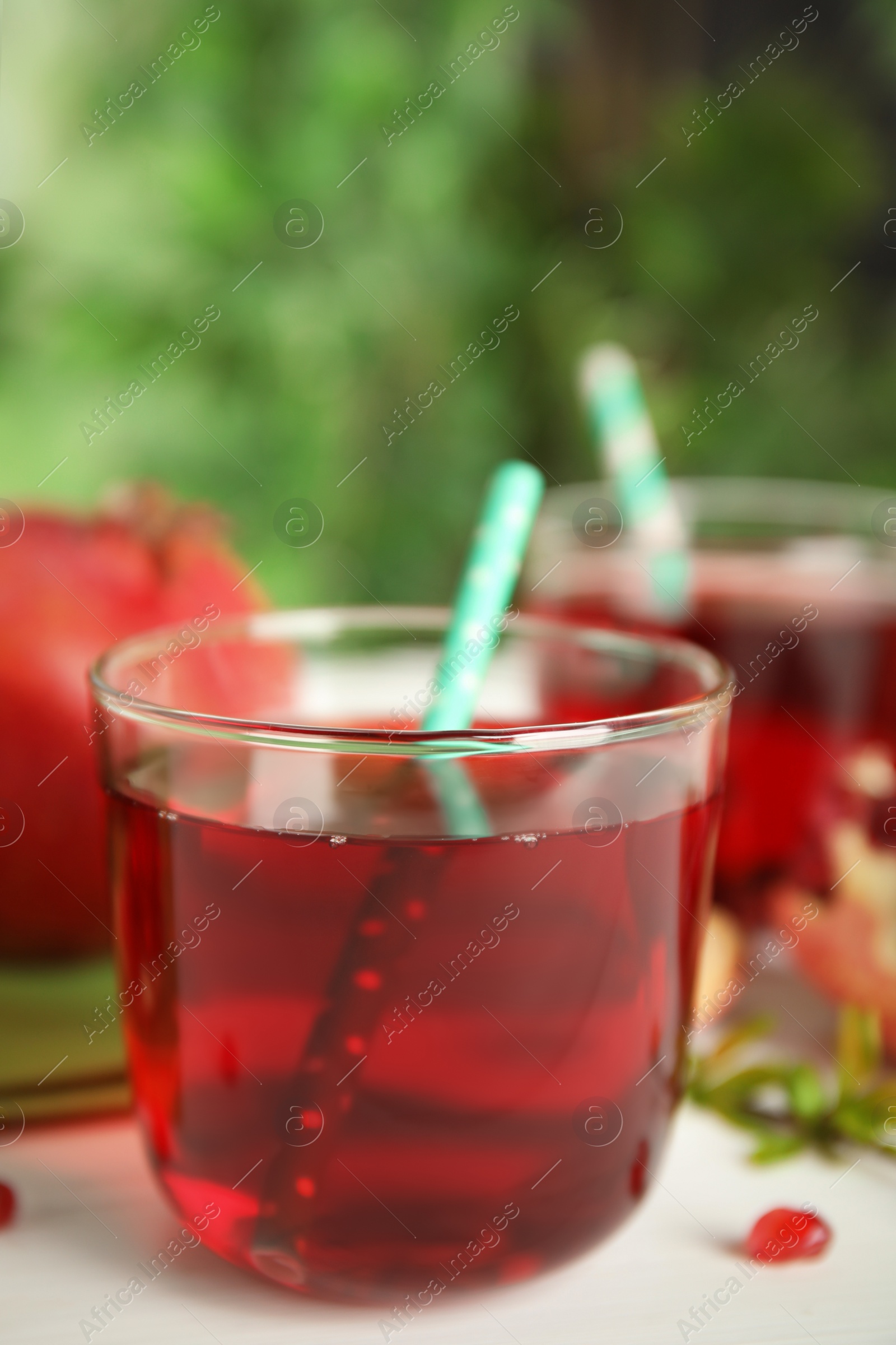 Photo of Pomegranate juice and fresh fruits on white table outdoors