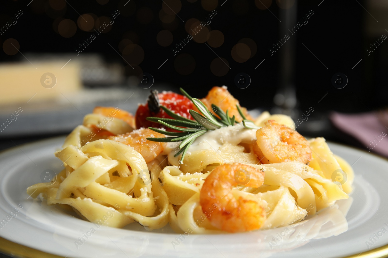 Photo of Delicious pasta with shrimps on black background, closeup