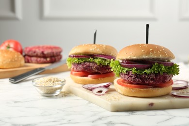 Photo of Tasty vegetarian burgers with beet patties on white marble table
