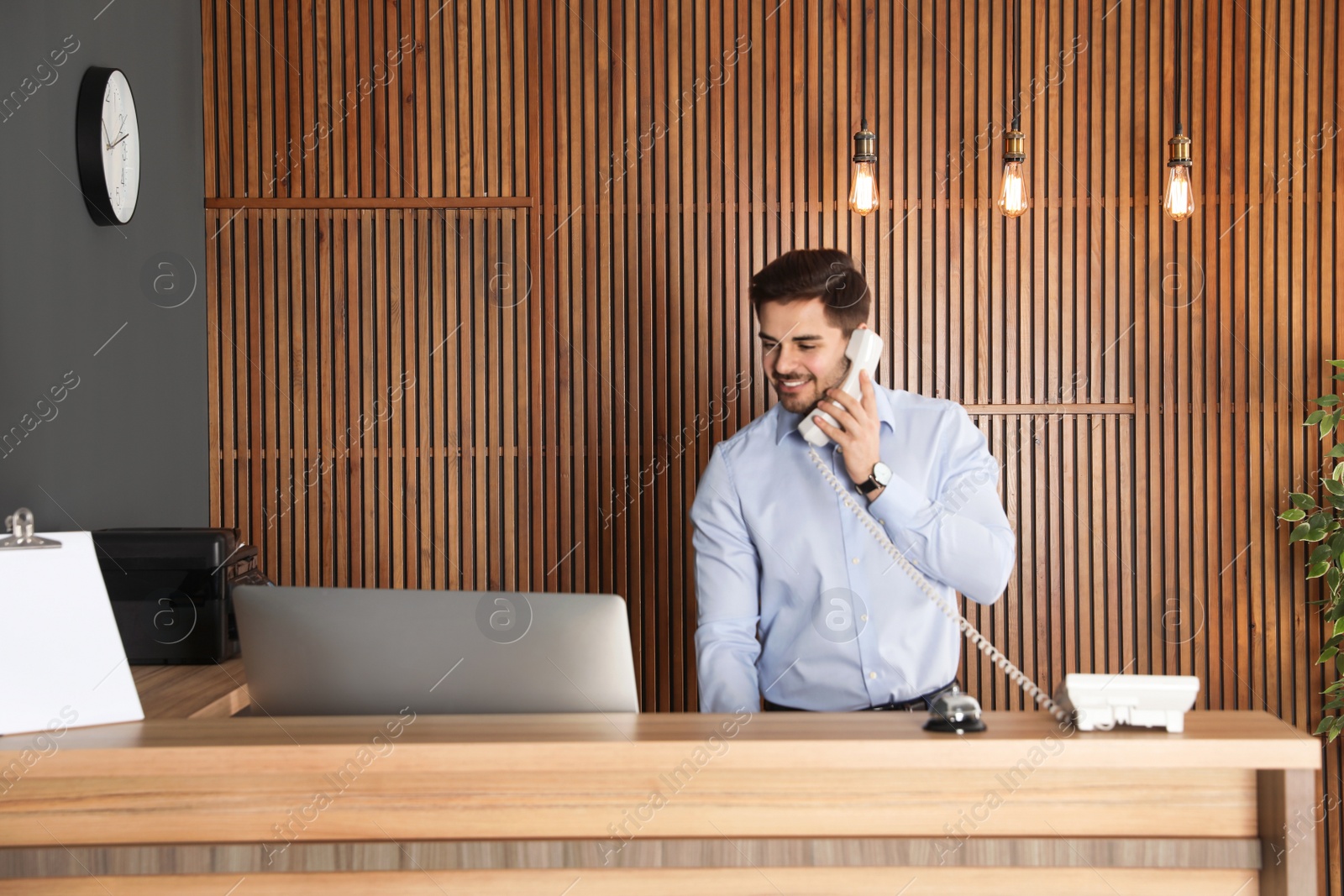 Photo of Receptionist talking on phone at desk in lobby