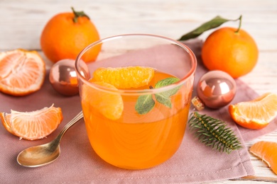 Photo of Delicious tangerine jelly in glass and fresh fruits on table