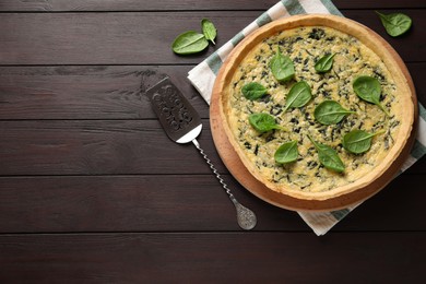 Photo of Delicious homemade spinach pie and spatula on wooden table, flat lay. Space for text