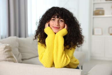 Photo of Young woman in stylish yellow sweater indoors