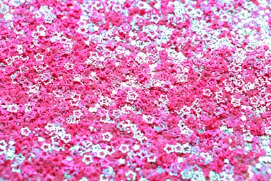 Photo of Beautiful pink sequins in shape of stars as background, closeup