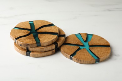 Photo of Stylish wooden cup coasters on white marble table