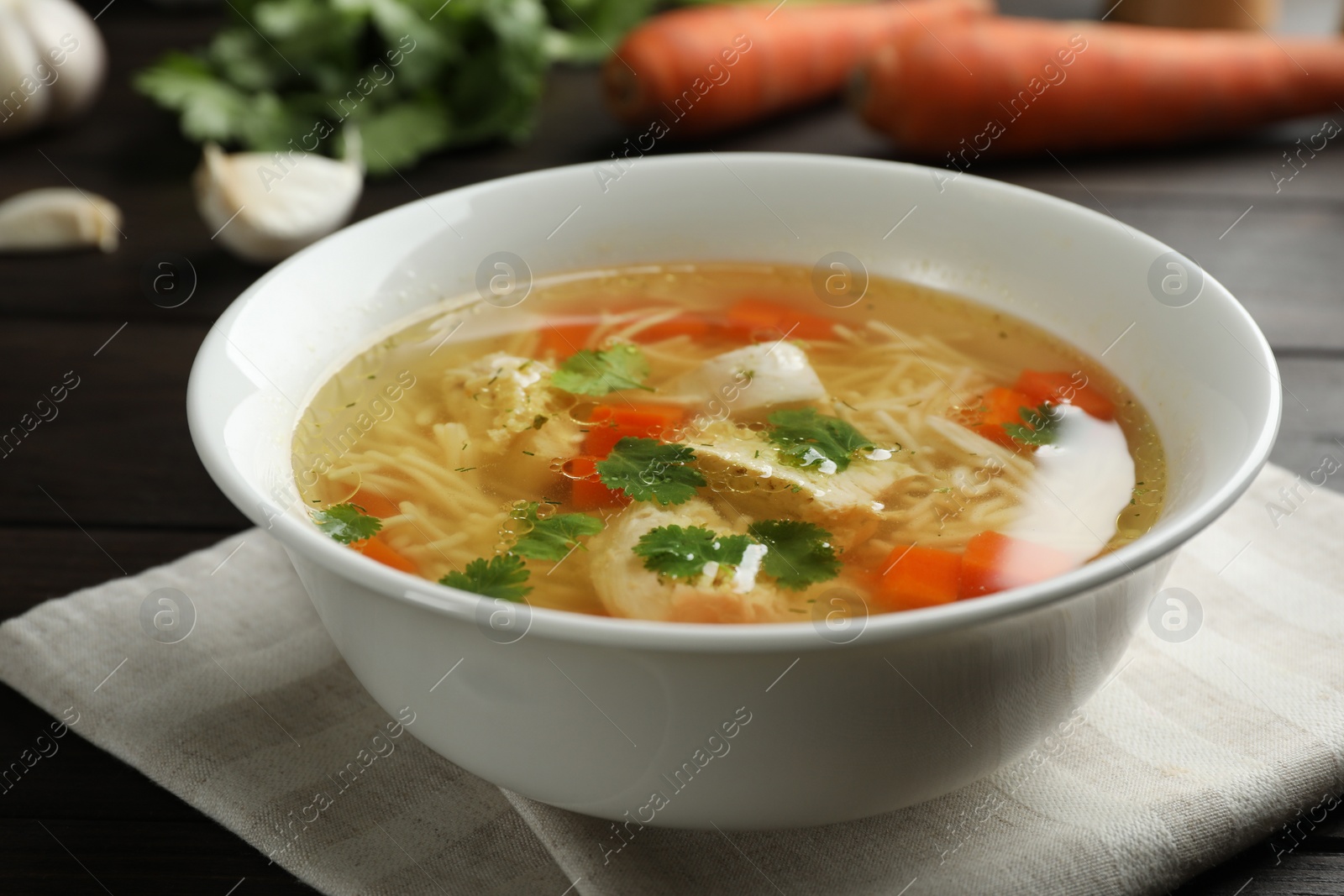 Photo of Dish with fresh homemade chicken soup on wooden table