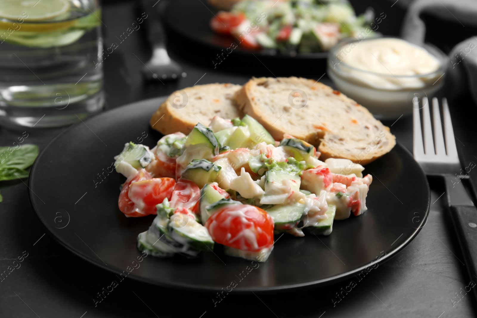 Photo of Delicious salad with mayonnaise on black table