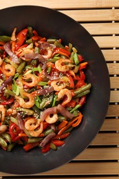 Photo of Shrimp stir fry with vegetables in wok on table, top view