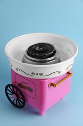 Photo of Portable candy cotton machine on light blue background