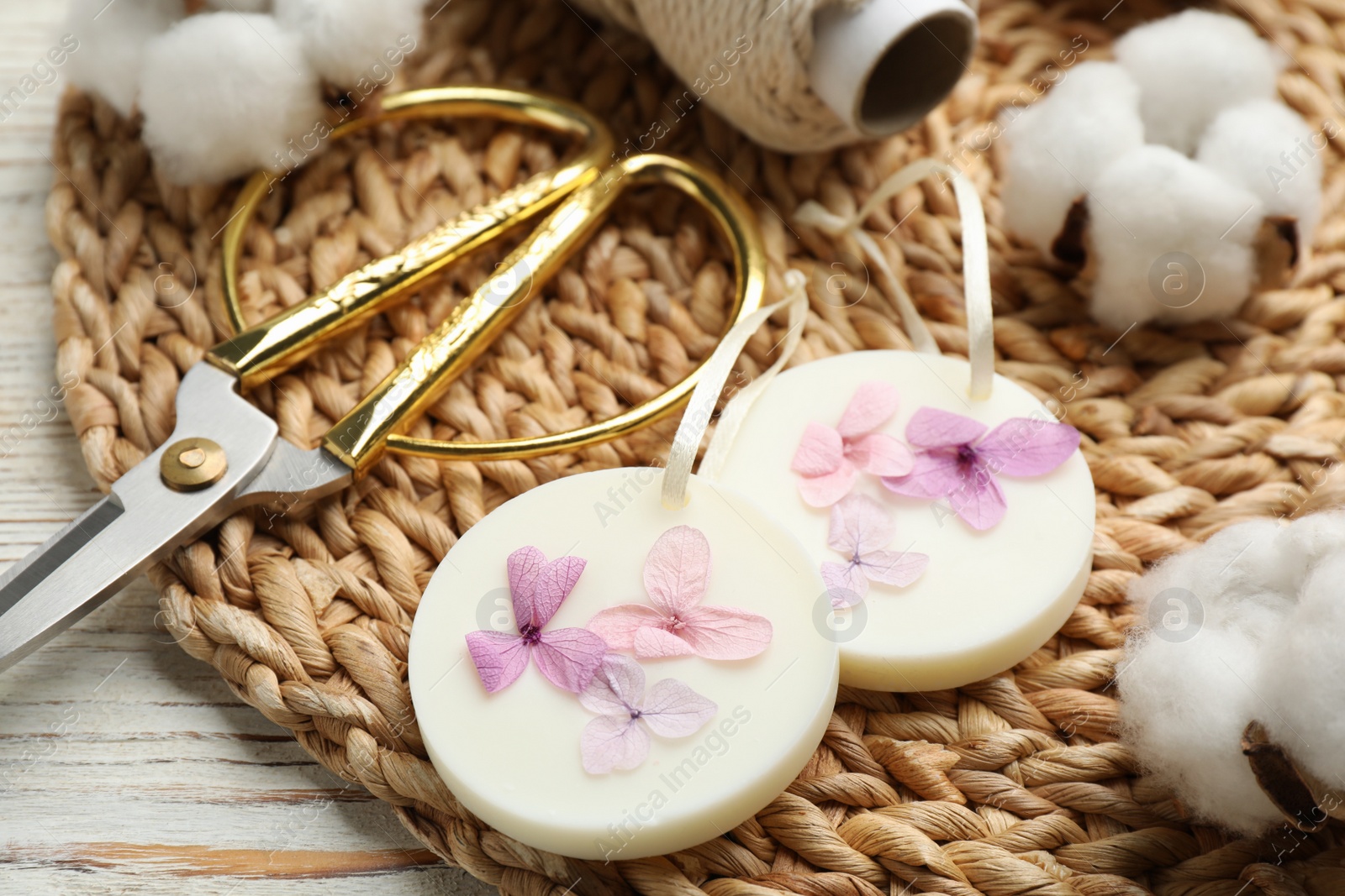 Photo of Composition with scented sachets, scissors and flowers on white wooden table