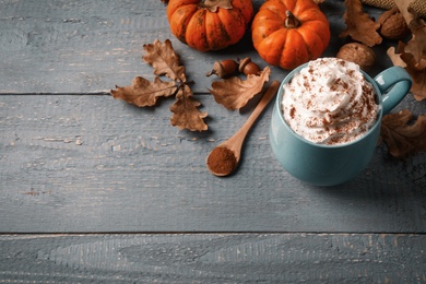 Delicious pumpkin latte on grey wooden table, above view. Space for text