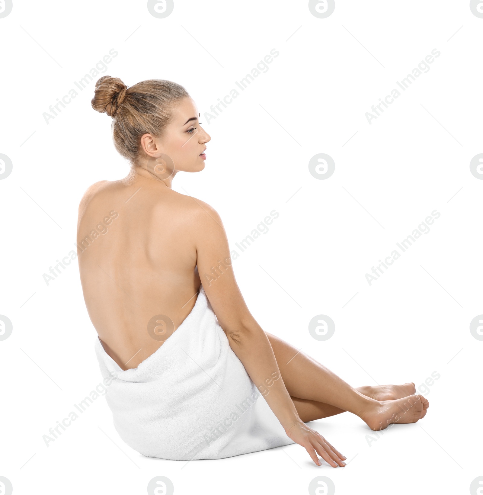 Photo of Young woman with soft towel sitting on white background