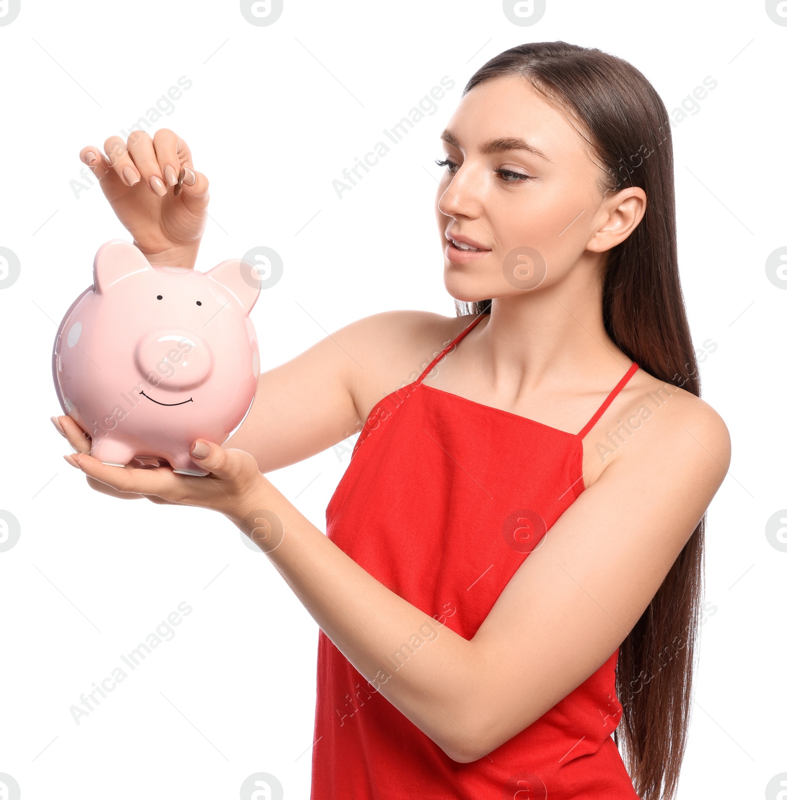 Photo of Young woman putting coin into piggy bank on white background