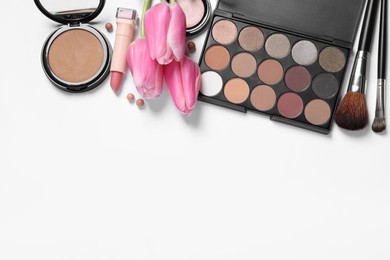 Photo of Flat lay composition with eyeshadow palette and beautiful tulips on white background, space for text