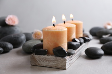 Beautiful composition with candles and spa stones on table