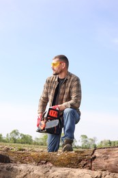 Man with modern saw on sunny day