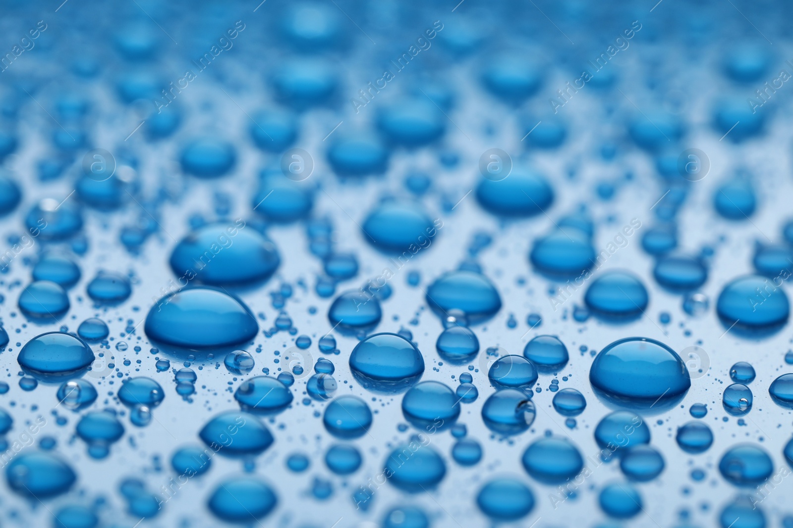 Photo of Water drops on blue background, closeup view