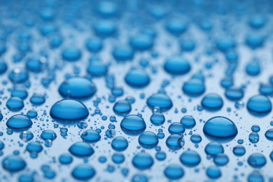 Water drops on blue background, closeup view