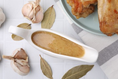 Flat lay composition with delicious turkey gravy in sauce boat on white tiled table