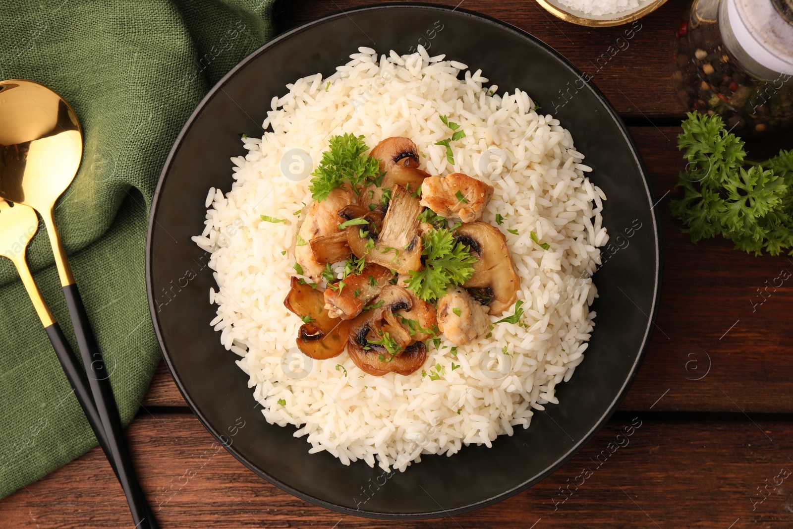 Photo of Delicious rice with mushrooms and parsley served on wooden table, flat lay