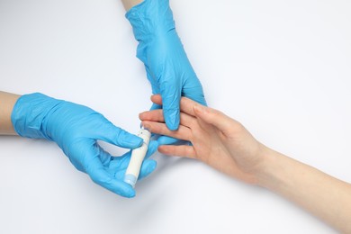 Photo of Diabetes. glucose testing. Doctor using lancet pen on white background, top view