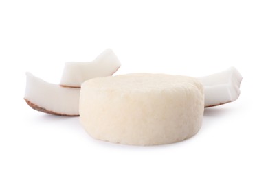 Solid shampoo bar and coconut pieces on white background. Hair care