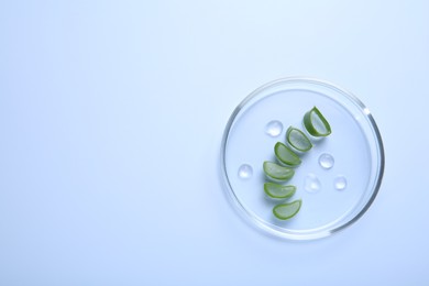 Photo of Cut aloe vera and drops of cosmetic gel on light blue background, top view. Space for text