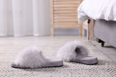 Photo of Grey soft slippers on carpet at home