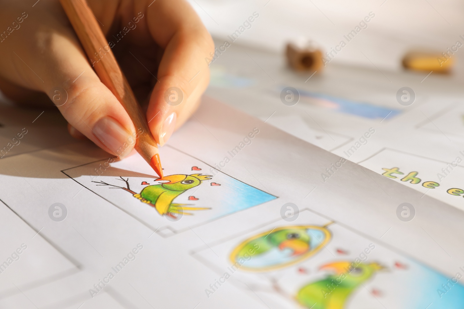 Photo of Woman drawing cartoon sketches at workplace, closeup. Pre-production process