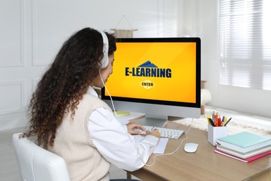 African American woman with headphones using modern computer for studying at home. E-learning