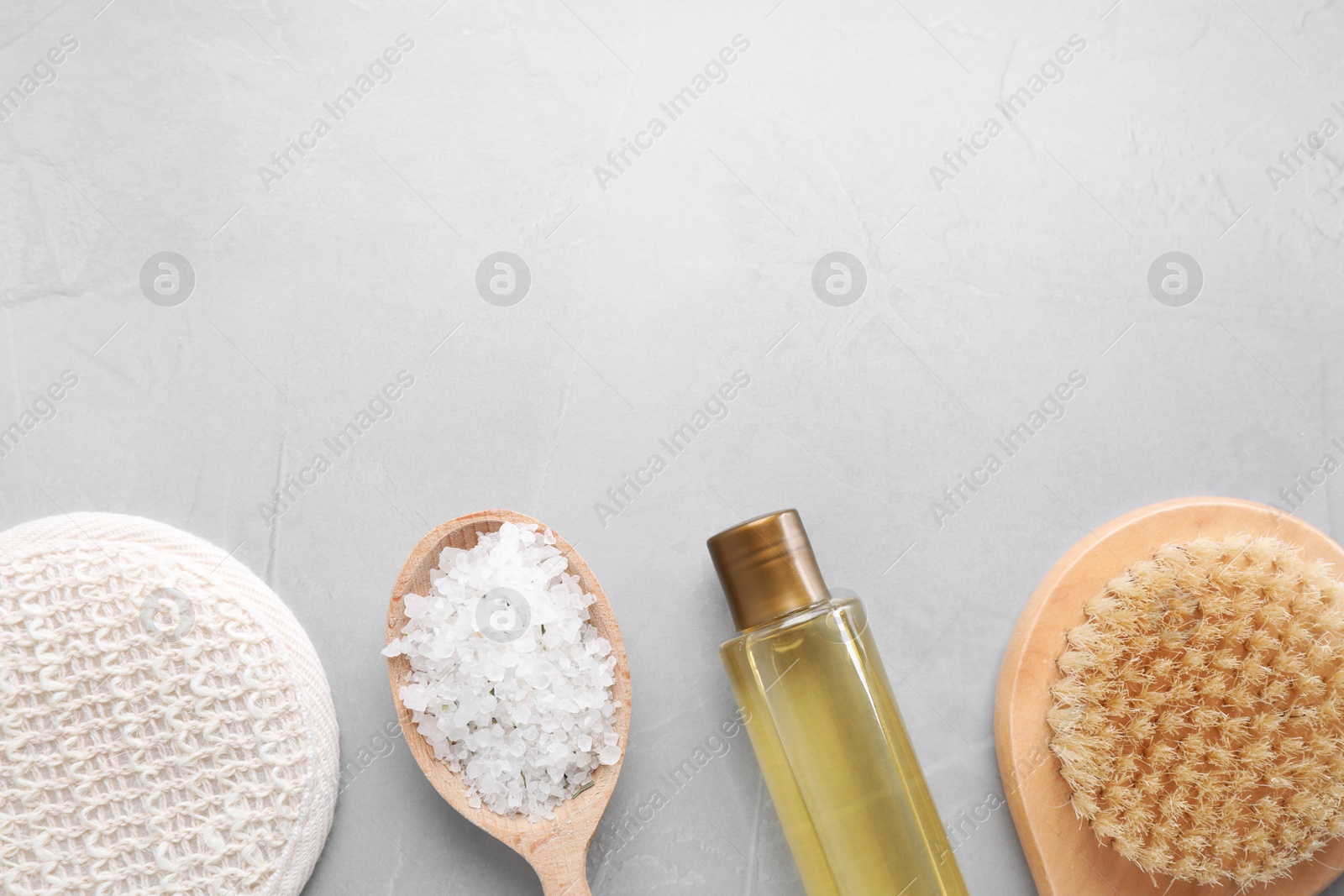 Photo of White sea salt and supplies for spa scrubbing procedure on wooden table, flat lay