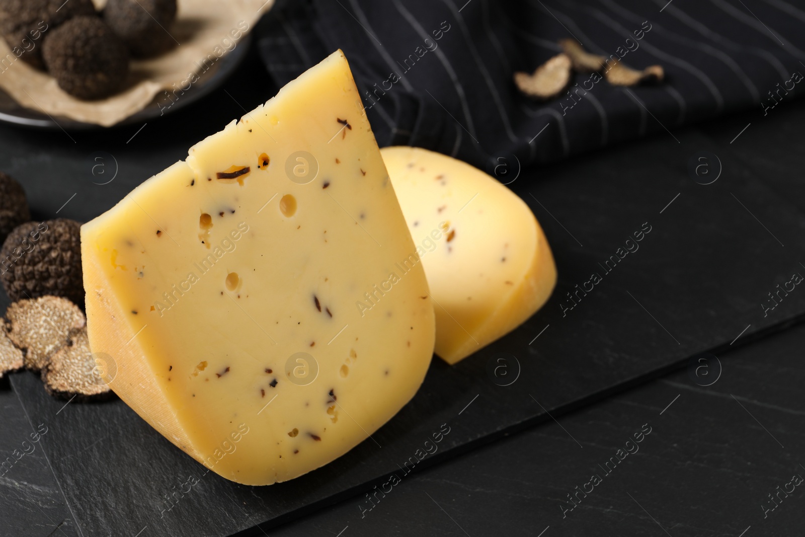 Photo of Fresh cheese and truffles on black table