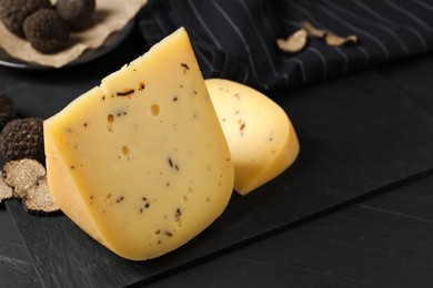 Photo of Fresh cheese and truffles on black table