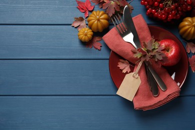 Photo of Festive table setting with autumn decor on blue wooden background, flat lay. Space for text