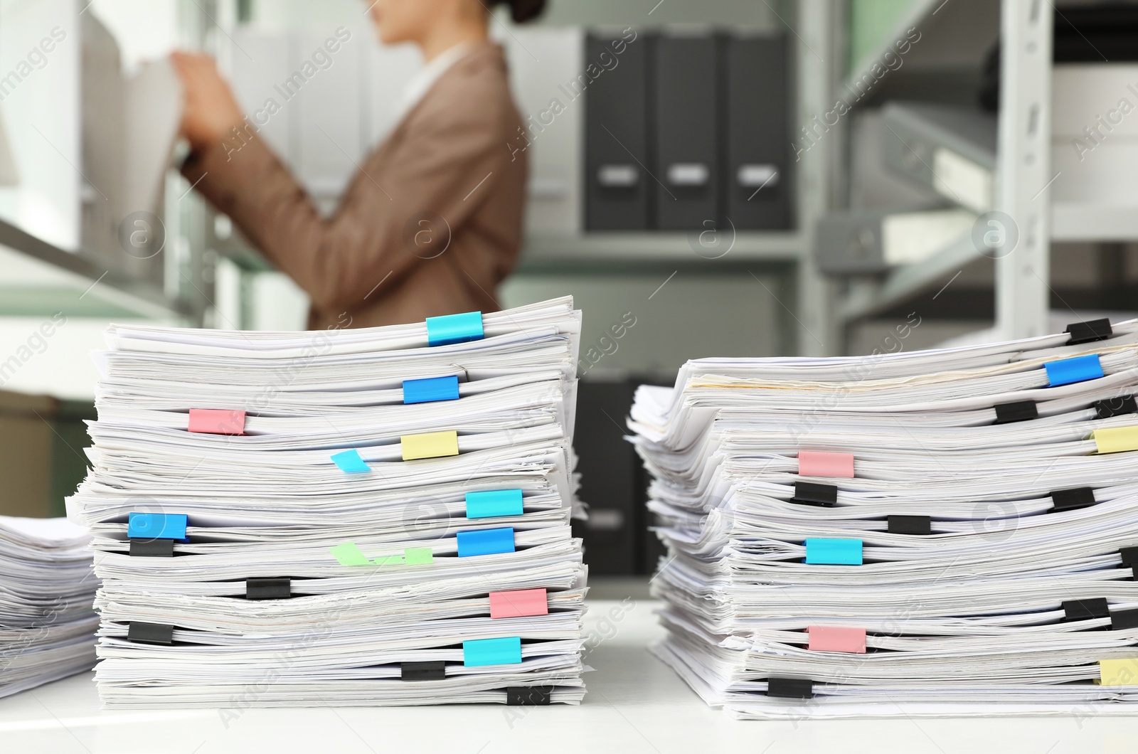 Photo of Stacks of documents with paper clips on office desk