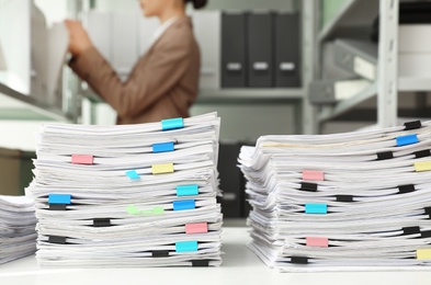 Stacks of documents with paper clips on office desk