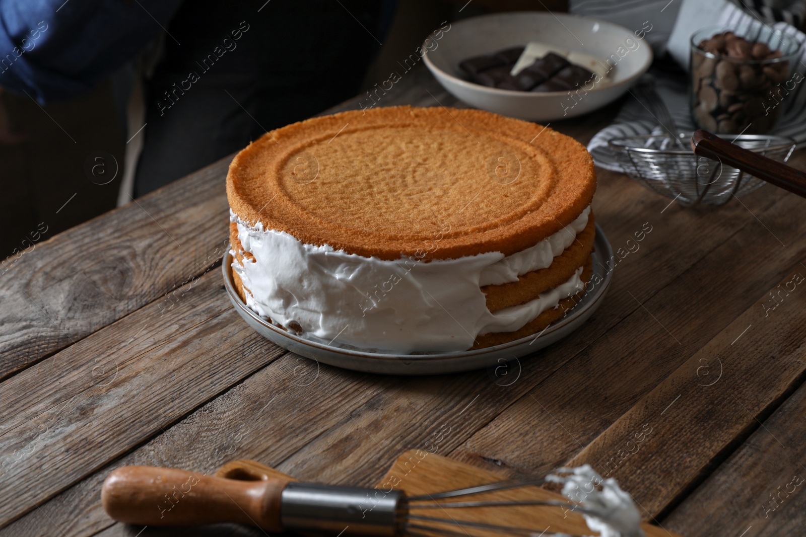 Photo of Delicious homemade layer cake with cream on wooden table