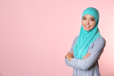 Photo of Portrait of young Muslim woman in hijab against color background. Space for text